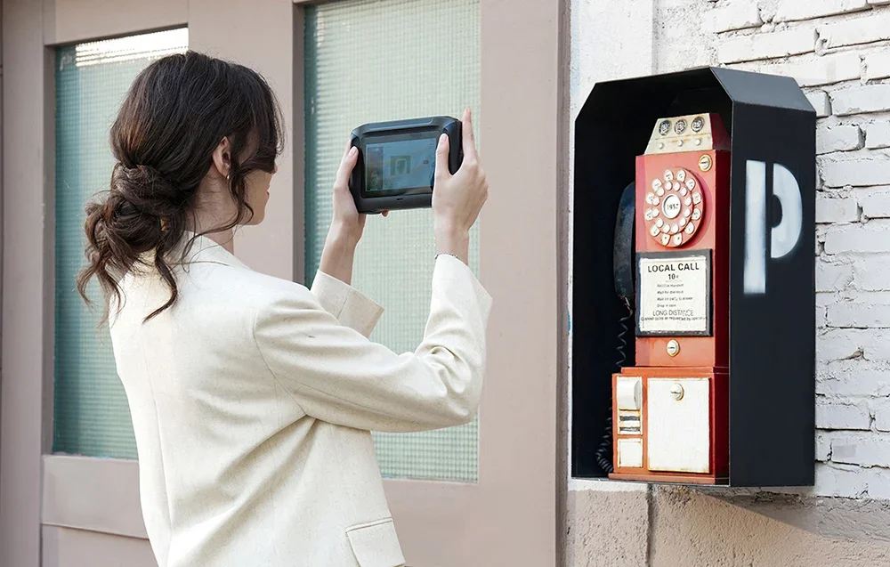 Skenuojamas senas raudonas sieninis telefonas