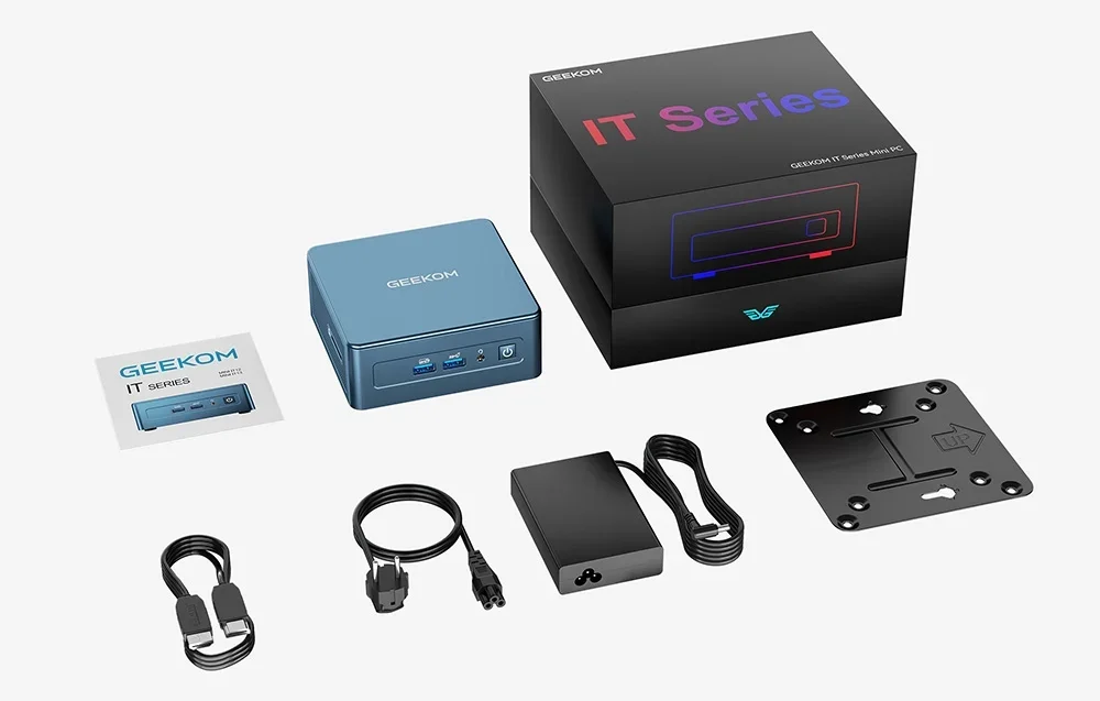 Mėlynas GEEKOM mini kompiuteris šalia juodos IT Series dėžutės, maitinimo adapterio, kabelių ir instrukcijos baltame fone